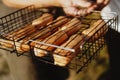 Delicious grilled sausages resting on the iron grid of a portable barbecue Royalty Free Stock Photo