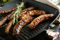Delicious grilled sausages with rosemary on pan, closeup Royalty Free Stock Photo