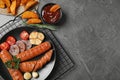 Delicious grilled sausages and on grey table, flat lay. Space for text Royalty Free Stock Photo