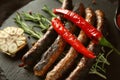 Delicious grilled sausages with vegetables and rosemary on slate plate, closeup Royalty Free Stock Photo