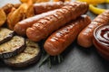Delicious grilled sausages and on slate plate, closeup. Barbecue food