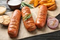 Delicious grilled sausages and on wooden table, closeup. Barbecue food