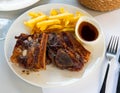 Grilled veal ribs with french fries and herbal sauce Royalty Free Stock Photo