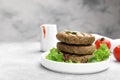 Delicious grilled vegan cutlets with lettuce on light grey table, closeup. Space for text Royalty Free Stock Photo