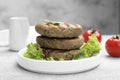 Delicious grilled vegan cutlets with lettuce on light grey table Royalty Free Stock Photo