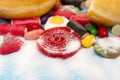 Delicious group of sweet sugar donut cakes and lots of gummy candies isolated in lifestyle nutrition health care