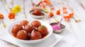 A delicious gulab jamun served on a white plate, holi banner