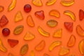 Delicious gummy fruit candies on orange background, flat lay