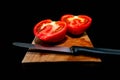 Delicious, half cutted home growth tomato on cherry cutting board