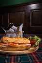 Delicious ham sandwich with cheese and village potatoes on a checkered tablecloth - vertical shot Royalty Free Stock Photo