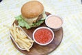 Delicious hamburgers and potato chips accompanied by warm tomato sauce.