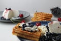 Delicious healthy breakfast. Belgian soft waffles with curd cheese cream and blueberry cherries lie white blue plate view from the Royalty Free Stock Photo