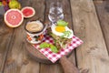 Delicious healthy breakfast. Toast with egg and basil, fragrant coffee and a glass of water. Pink grapfruit. Cinnamon wooden