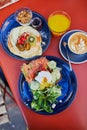 Delicious healthy brunch with avocado and salmon toast, boiled egg, pancakes with fruits and maple syrup