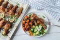 Baked chicken drumsticks with sweet potatoes and cucumber salad on a plate. Healthy low fat dinner or lunch Royalty Free Stock Photo