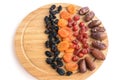 Delicious healthy dried fruits on a wooden kitchen board - apricot, dates, dried cherries, dark raisins. Healthy food for breakfas Royalty Free Stock Photo