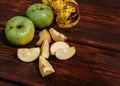 Delicious and healthy food for healthy and active people. Two whole green apples and one red Apple cut into pieces are lying on Royalty Free Stock Photo