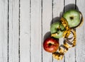 Delicious and healthy food is on the kitchen table. Three apples-yellow, green and red on a white wooden background and a yellow Royalty Free Stock Photo