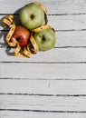 Delicious and healthy food is on the kitchen table. Three apples-yellow, green and red on a white wooden background and a yellow Royalty Free Stock Photo