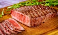 Delicious and healthy grilled medium rare beef steak on wooden board Royalty Free Stock Photo