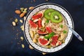 Delicious and healthy oatmeal with figs, nuts, kiwi and seeds.