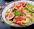 Delicious and healthy oatmeal with figs, nuts, kiwi and seeds.