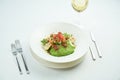 A delicious and healthy salad with artichokes, avocado, tuna and quinoa, served in a white plate on a white tablecloth. Restaurant Royalty Free Stock Photo