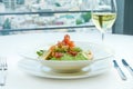 A delicious and healthy salad with artichokes, avocado, tuna and quinoa, served in a white plate on a white tablecloth. Restaurant Royalty Free Stock Photo