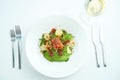 A delicious and healthy salad with artichokes, avocado, tuna and quinoa, served in a white plate on a white tablecloth. Restaurant Royalty Free Stock Photo