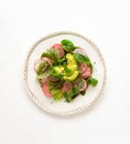 Delicious healthy salad of fresh avocado, radish, lettuce, microgreens on white plate. Clean eating. Top view Royalty Free Stock Photo