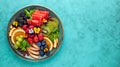 Delicious healthy salad of fresh fruits, berries and edible flowers on plate. Clean eating. Top view