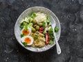 Delicious healthy vegetarian breakfast, brunch, lunch - couscous, boiled egg, avocado, fresh vegetables, hummus in one bowl on a Royalty Free Stock Photo