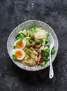 Delicious healthy vegetarian breakfast, brunch, lunch - couscous, boiled egg, avocado, fresh vegetables, hummus in one bowl on a Royalty Free Stock Photo