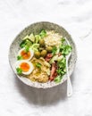 Delicious healthy vegetarian breakfast, brunch, lunch - couscous, boiled egg, avocado, fresh vegetables, hummus in one bowl on a Royalty Free Stock Photo