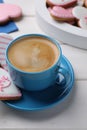 Delicious heart shaped cookies and cup of coffee on white wooden table Royalty Free Stock Photo