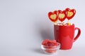 Delicious heart shaped lollipops, dragees and jelly candies on light background