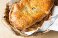 Delicious home baked apple and raisins turnover slab pie with cinnamon and nutmeg filling in wicker basket on rustic wooden table Royalty Free Stock Photo