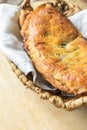 Delicious home baked apple and raisins turnover slab pie with cinnamon and nutmeg filling in wicker basket on rustic wooden table Royalty Free Stock Photo