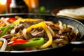 Delicious home cooked beef steak fajitas in iron cast skillet with colorful sweet peppers and onions