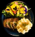 Delicious home cooked potato meat fresh garden salad with flower petals and natures greens