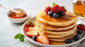 Delicious homemade american pancakes with fresh berries and honey on white background