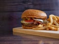 Homemade Bacon Cheese Burger with Onion Rings and Spicy French Fries Royalty Free Stock Photo