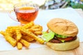 Delicious Homemade beef burger with mushrooms, micro greens, red onion, beet sauce on wooden board. Royalty Free Stock Photo