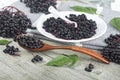 Delicious homemade black elderberry syrup and bunches of black elderberry with green leaves on wooden desk. Elderberry syrup