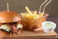 delicious homemade burger from meat, cheese and vegetables with french fries on an old wooden table. Close-up of unhealthy fatty Royalty Free Stock Photo