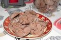 Delicious homemade cacao christmas cookies in a christmas plate and a jar and candle in the back Royalty Free Stock Photo