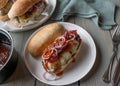 Cheeseburger on french baguette bun with melted cheese, barbecue sauce, onions, tomatoes and pickles on a plate open faced Royalty Free Stock Photo