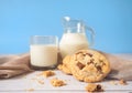 Delicious homemade chocolate chip cookies, paired with fresh milk in a glass and pitcher, placed on a white wooden floor and a Royalty Free Stock Photo