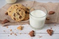 Delicious homemade chocolate chip cookies, paired with fresh milk in a glass and pitcher, placed on a white wooden floor and a Royalty Free Stock Photo