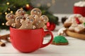 Delicious homemade Christmas cookies in cup on white wooden table against blurred festive lights. Space for text Royalty Free Stock Photo